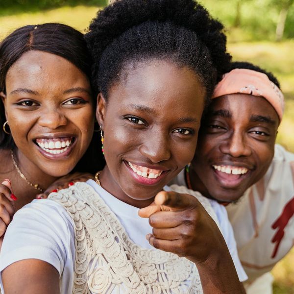 Diverse group of people smiling during a light yoga session outdoors.
