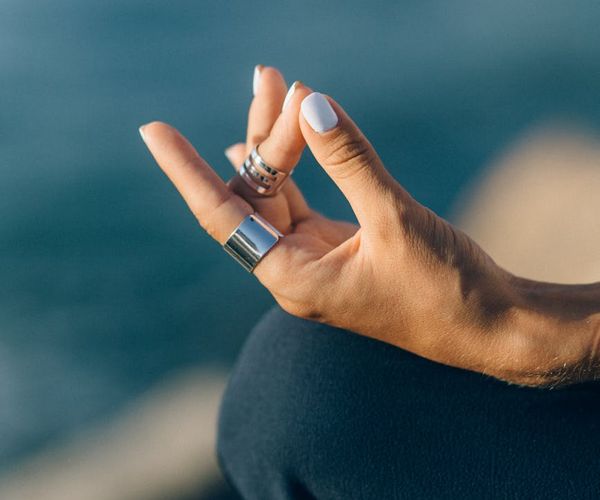 Woman in a peaceful yoga pose against a calm blue background.